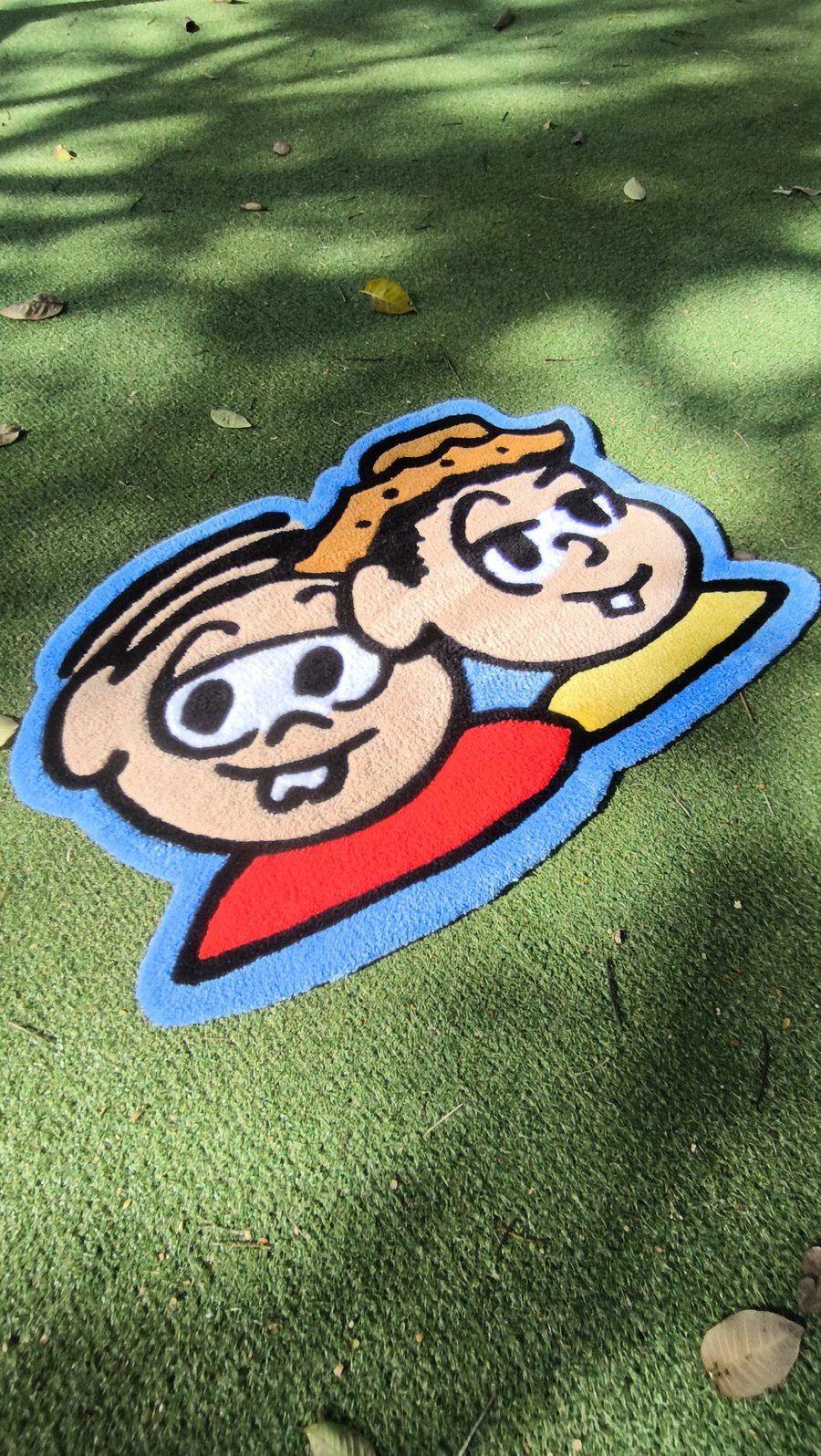 Tapete com dois personagens animados, Mônica e Chico Bento